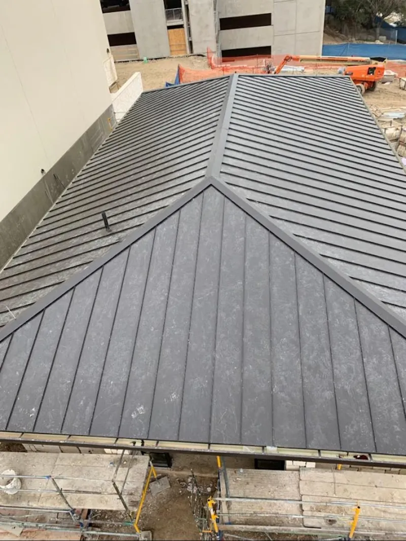 Commercial metal roof construction with crane equipment in Calumet