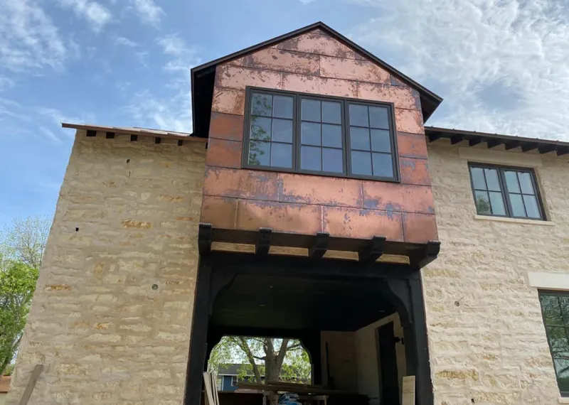 Copper metal panel facade on a stone building for Skylight Installation in Calumet
